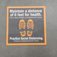 A sticker on the floor with foot prints asking to maintain six feet of distance.