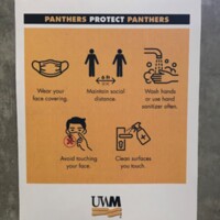 Photograph of a social distancing guidelines sign at UWM