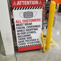 A sign saying that all customers must wear a mask including those who have been vaccinated