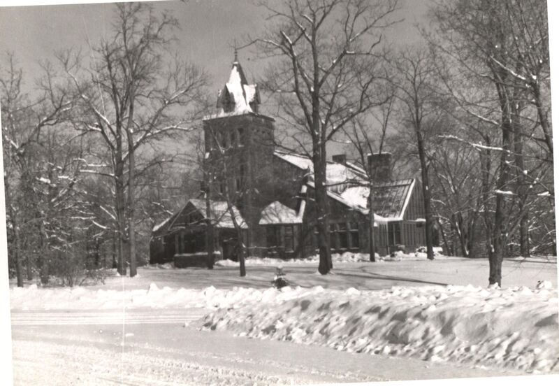 Black and white photo of outside the Chapel during wintertime with snow all around.