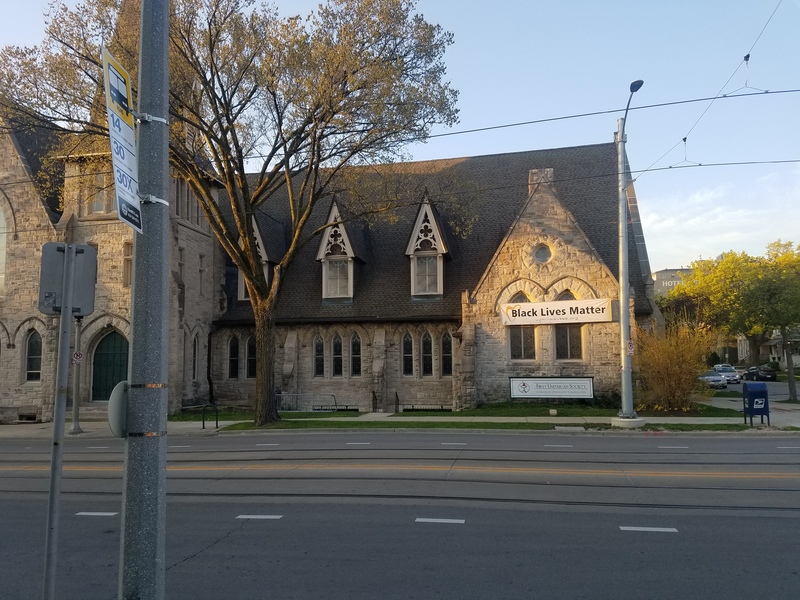 Photograph showing the exterior the of First Unitarian Church's third church. A banner stating "Black Lives Matter" is hung from the exterior.