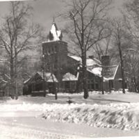 Black and white photo of outside the Chapel during wintertime with snow all around.